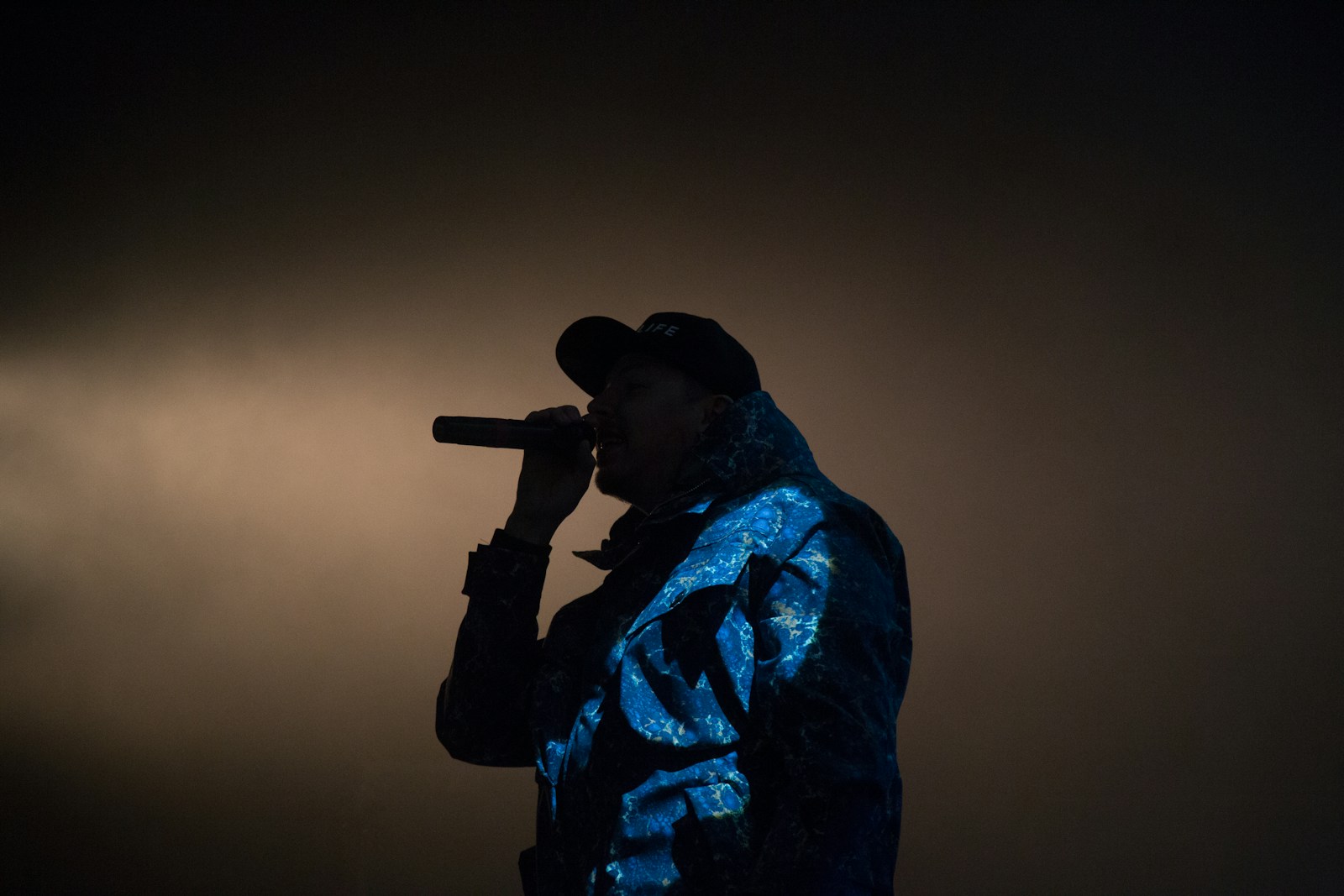 man holding microphone low light photography